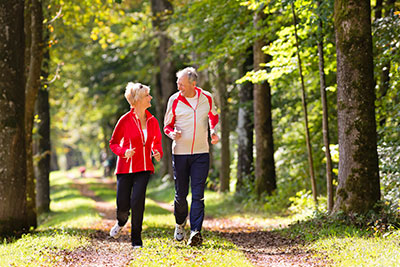 elderly couple walking through park in upland california