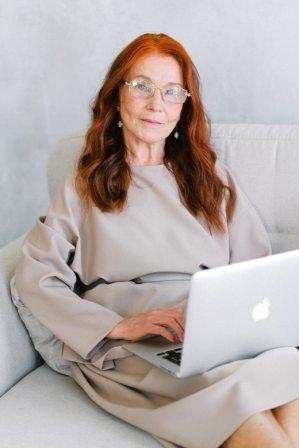 a person sitting on a bed using a laptop